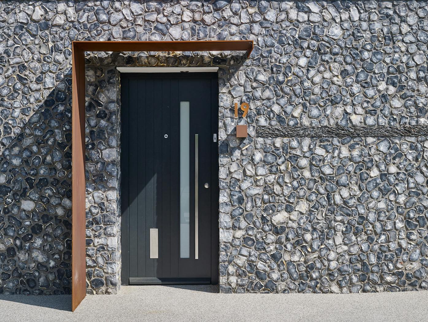 A rust overhang/porch and rust number mixed with stainless steel accessories
