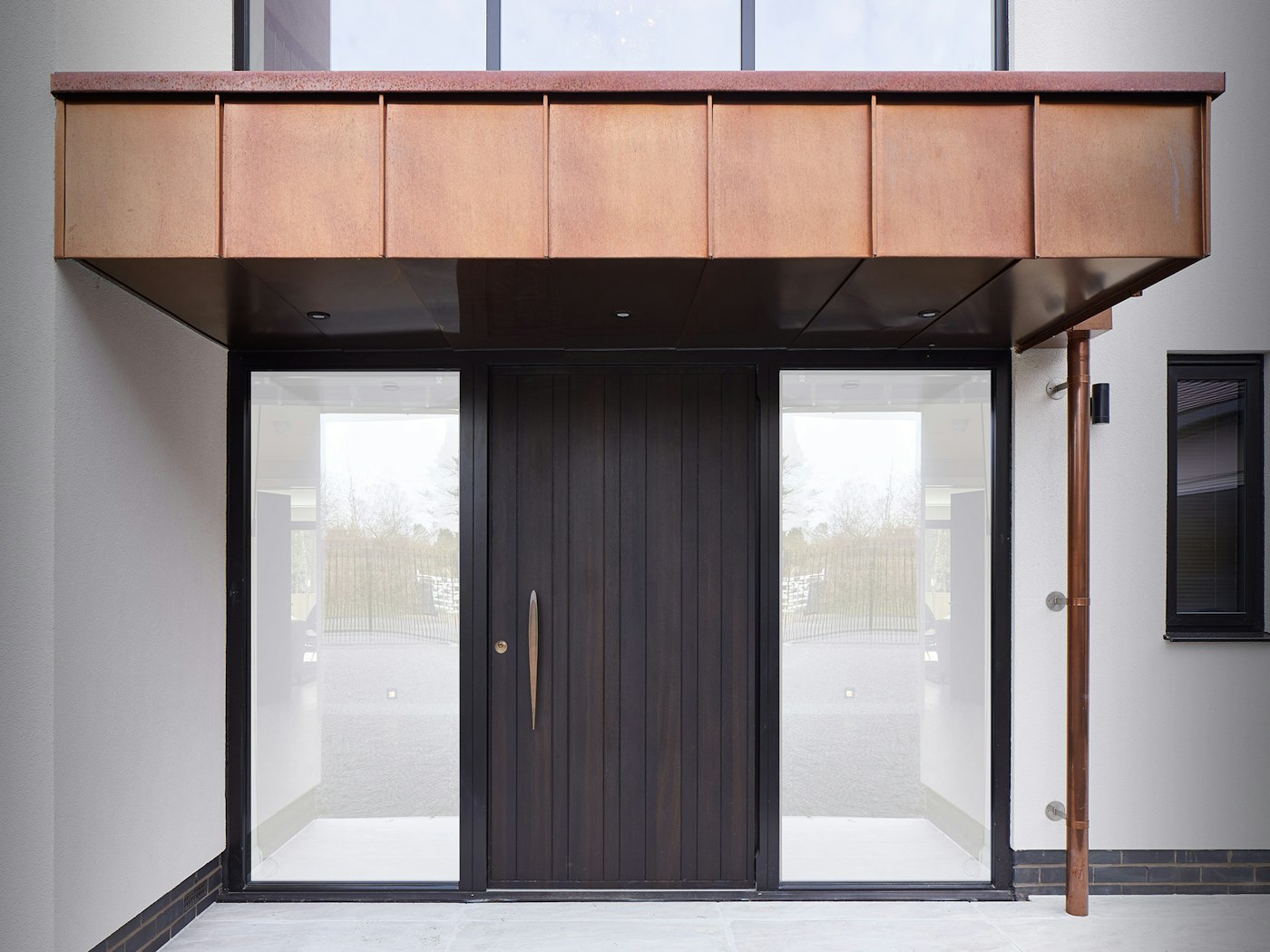 This copper canopy perfectly complements the fumed oak front door & bronze handle 
