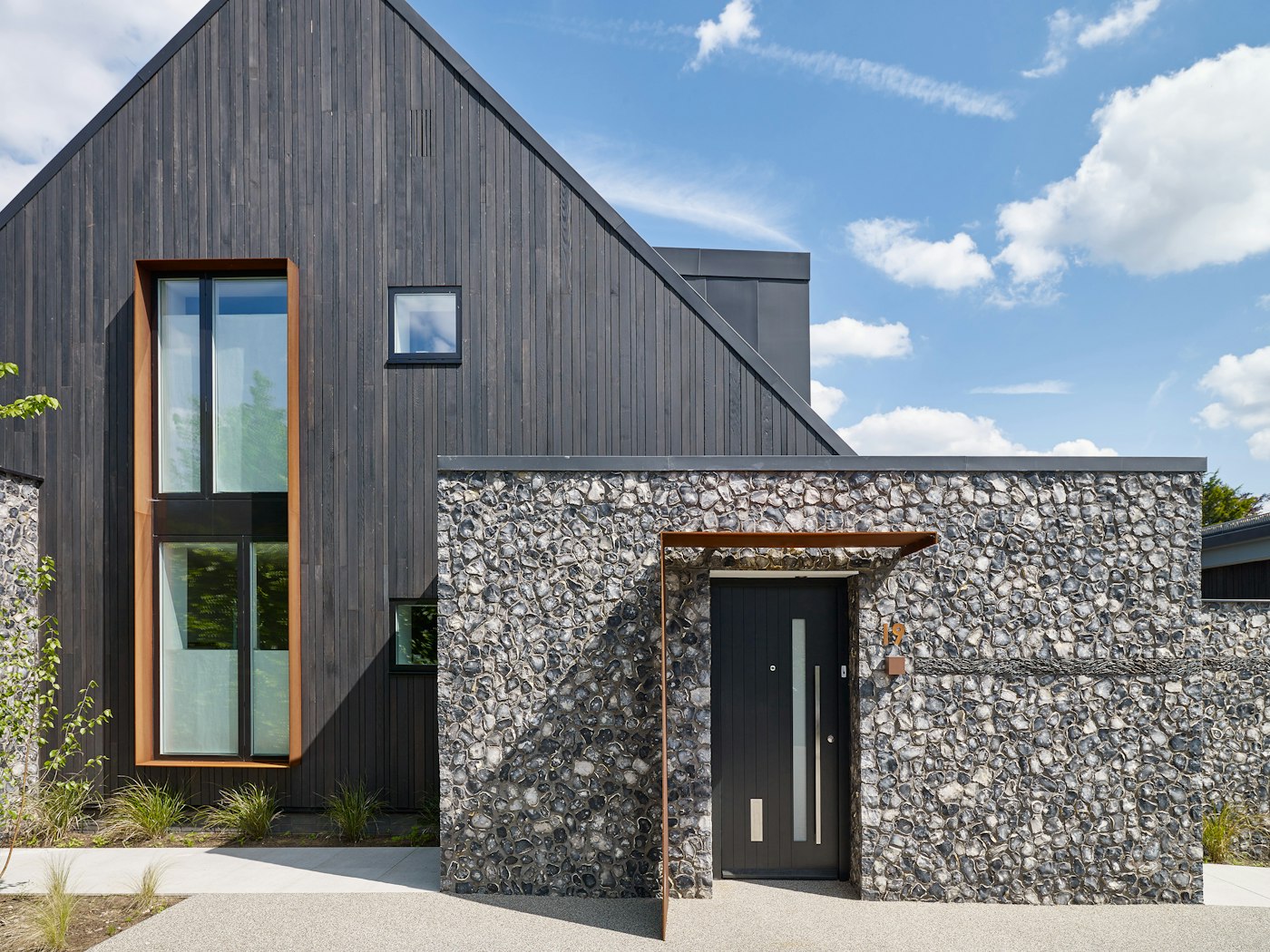 Here the door is highlighted by stunning flint work and the rest of the building includes burnt cedar cladding