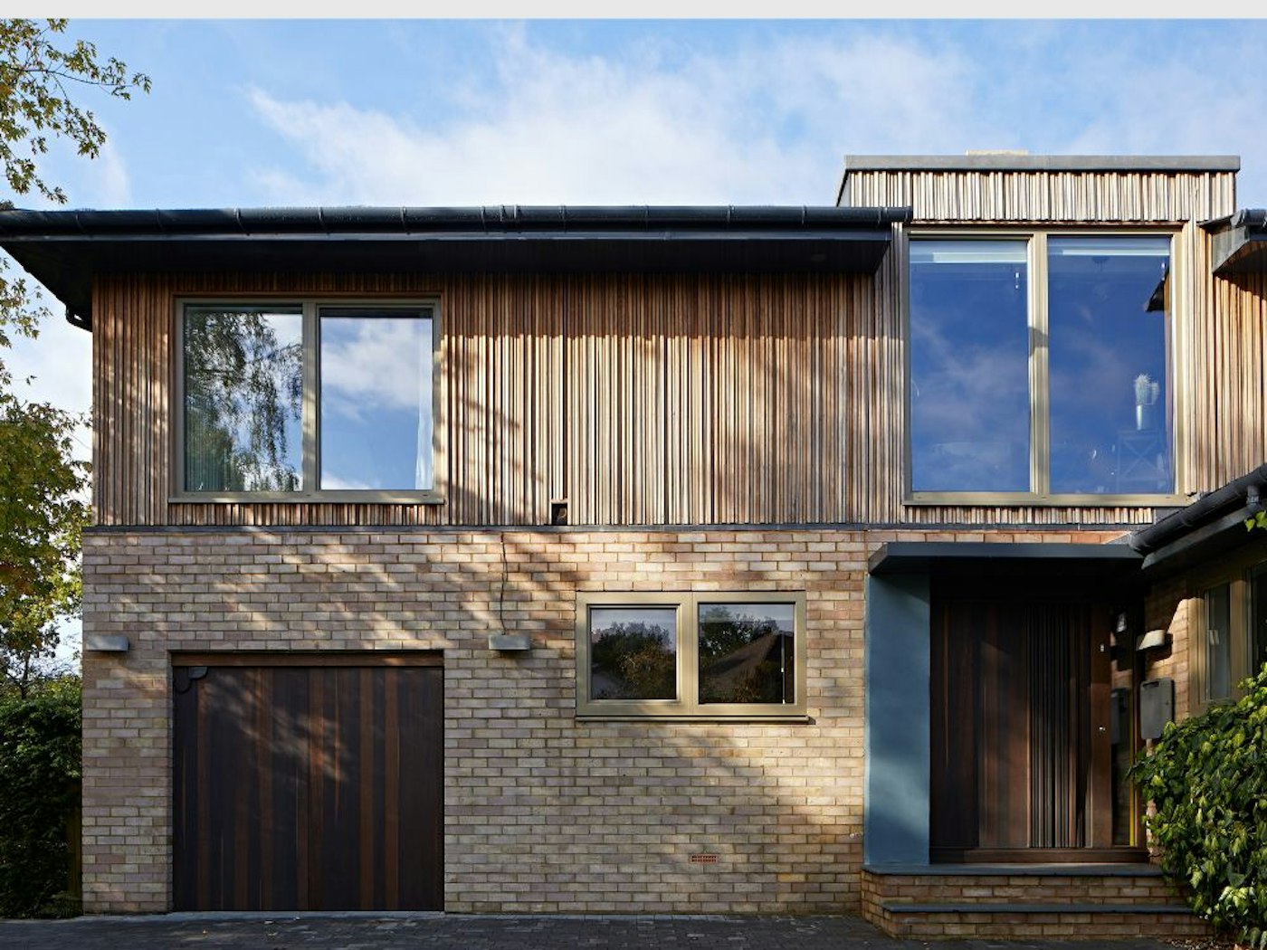 The iroko cladding works beautifully with the fumed oak front and garage doors.
