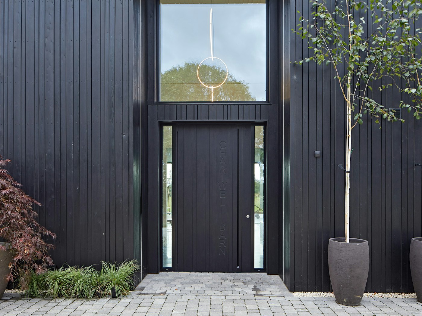 Sleek and modern, the "Chartwell Barn" project used an ebony-oiled oak wood door to match to the exterior cladding