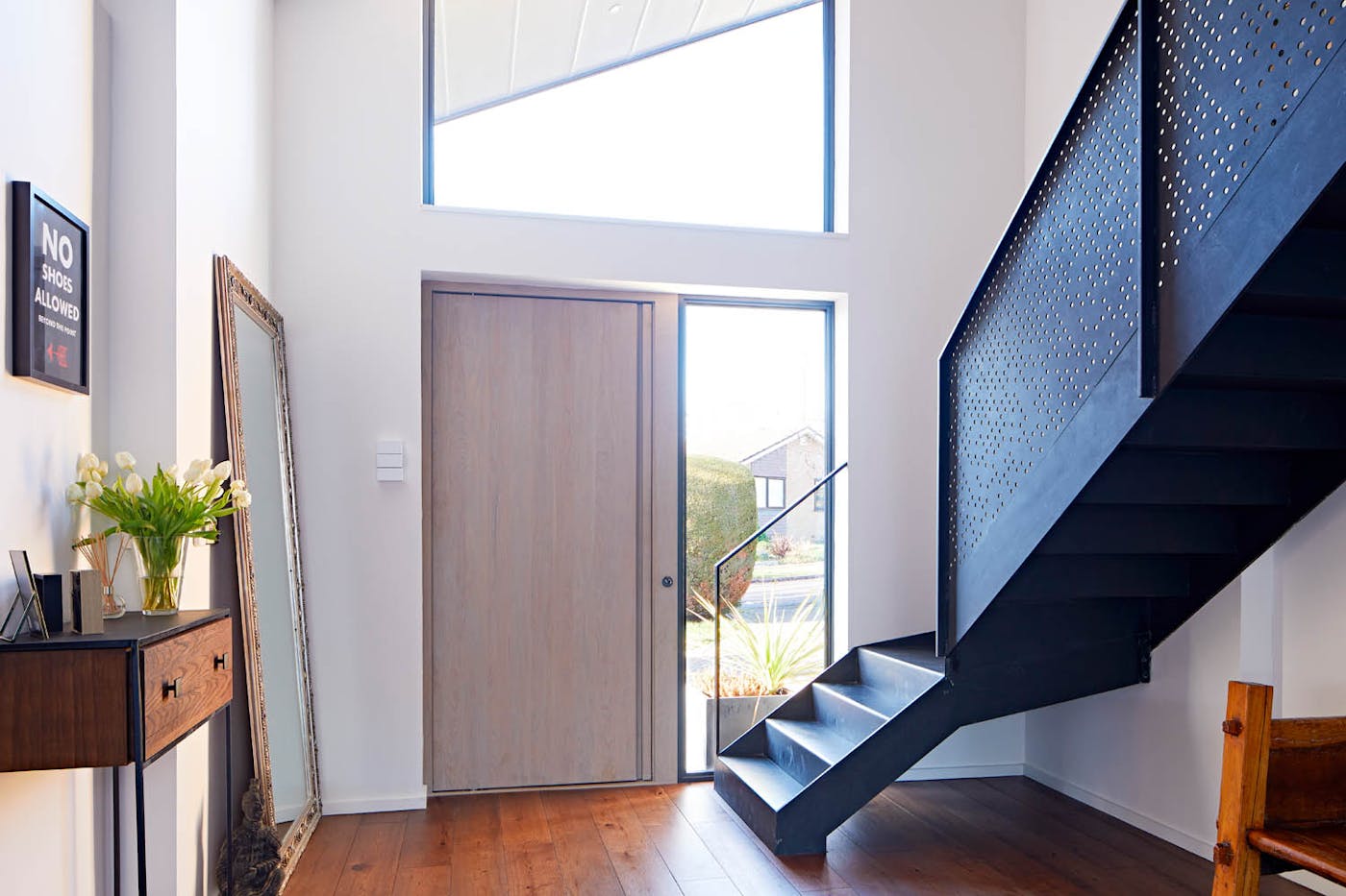 The simplicity of the "Raw" design is accentuated by a grey oil finish and concealed handle, allowing the dramatic staircase to become the focal point of the interior