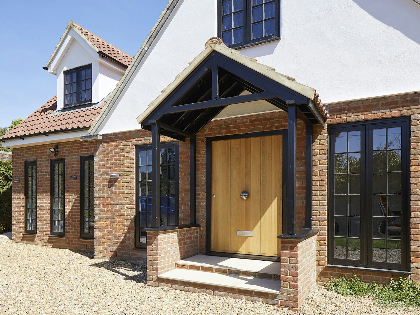 Outside, this oak front door blends nicely with the more traditional styling and red brick & white render materials