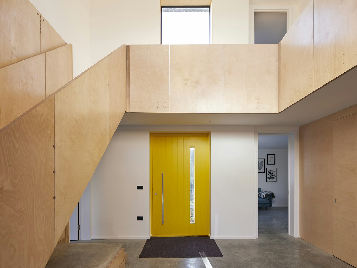 The bold yellow door makes an impactful statement on the entrance hall