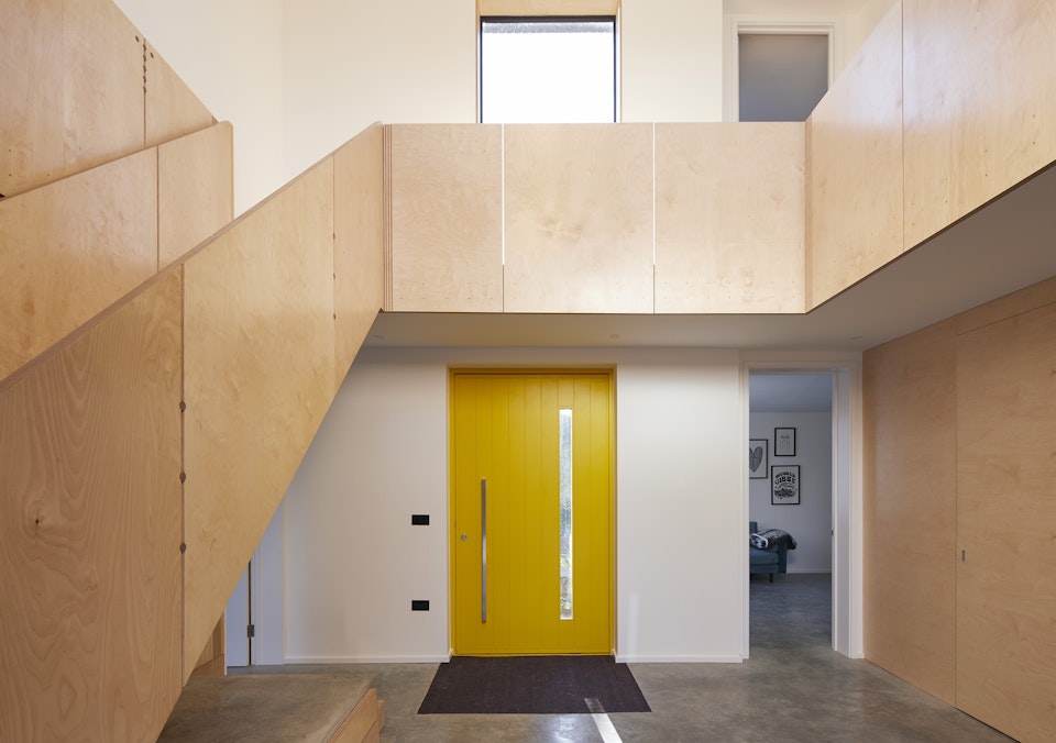 The bold yellow door makes an impactful statement on the entrance hall