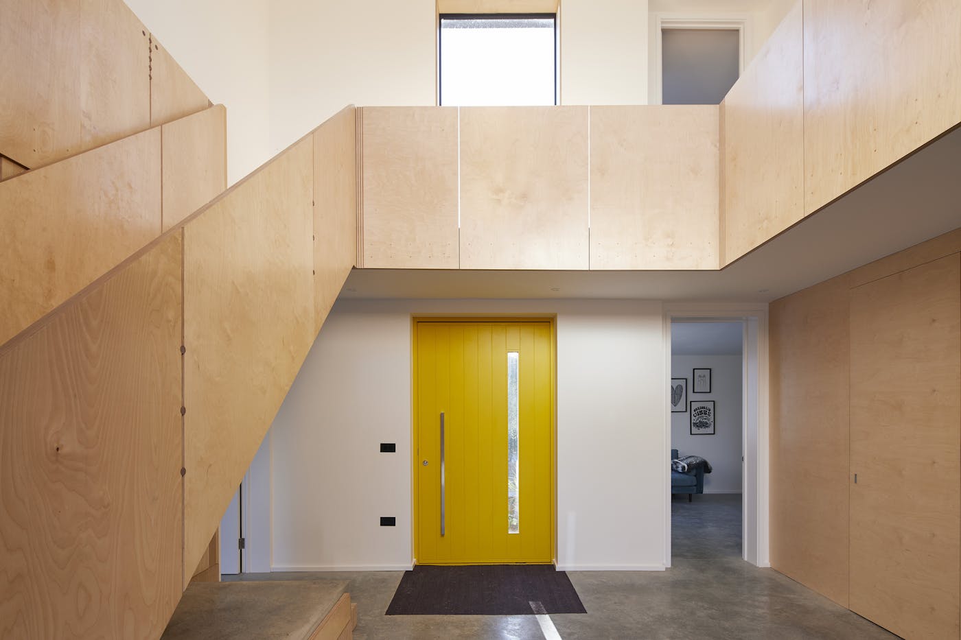 The bold yellow door makes an impactful statement on the entrance hall