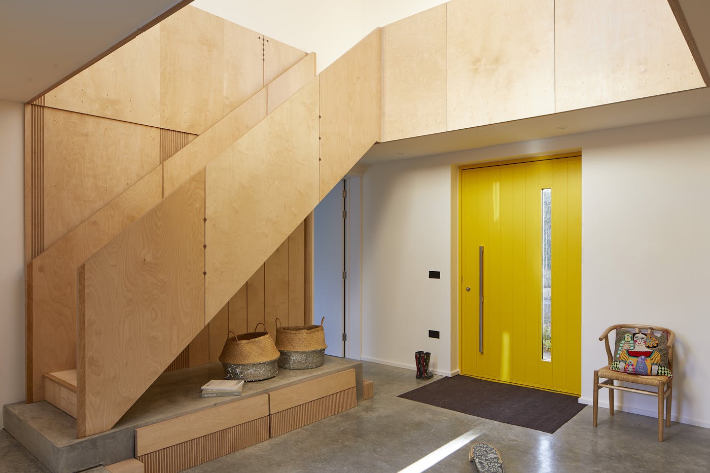 An occasional chair with colourful cushion and complementary baskets give character without the clutter