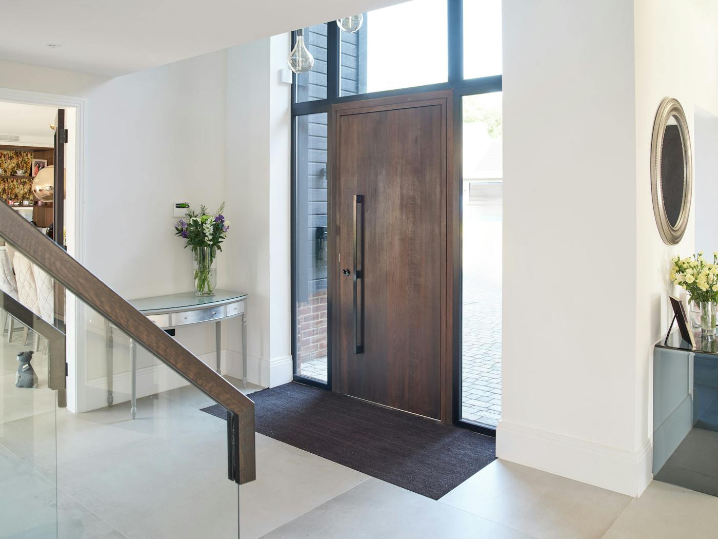 White walls and flooring contrast with the beautiful dark fumed oak door 