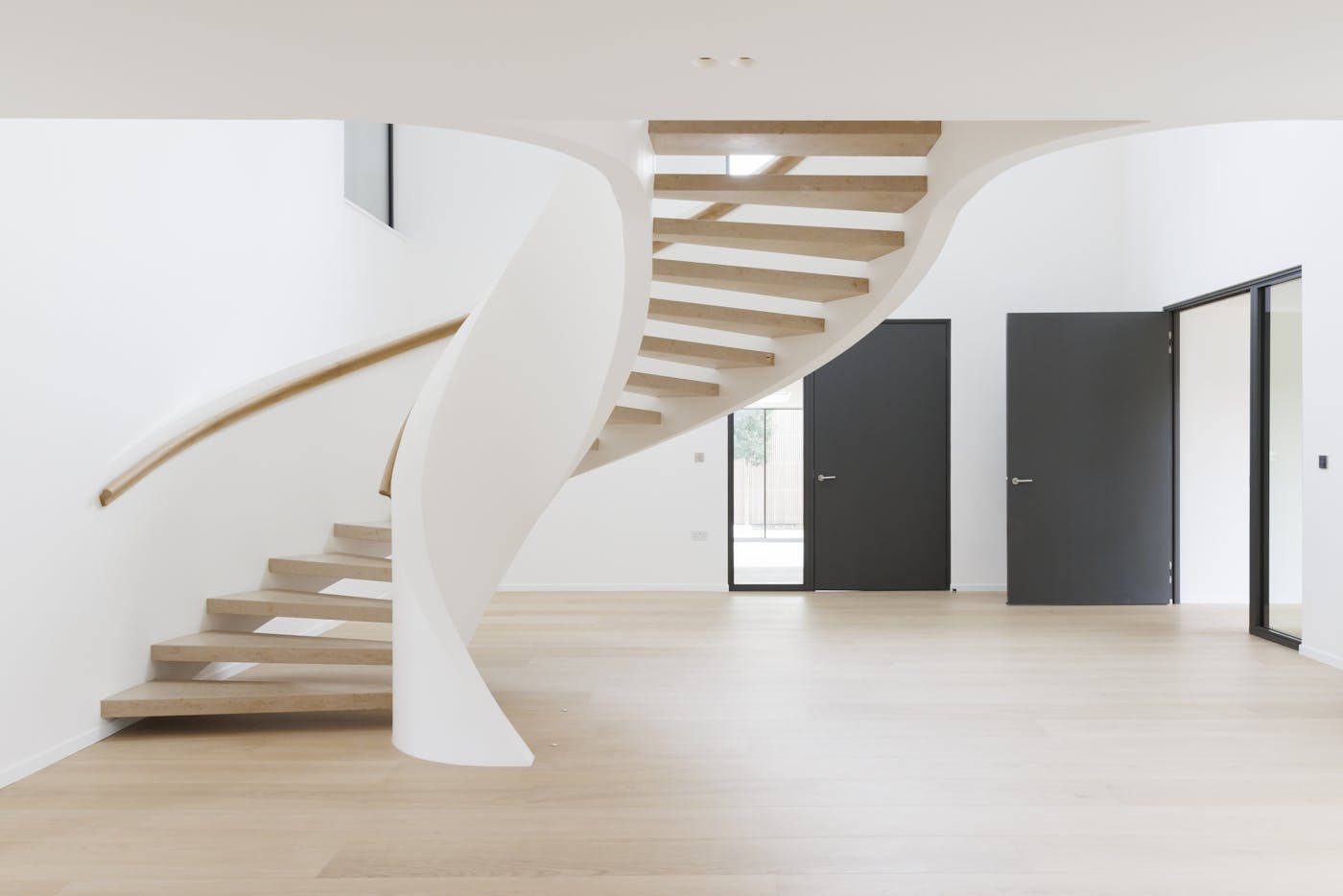 Staircase as art form in this pared back spacious hallway