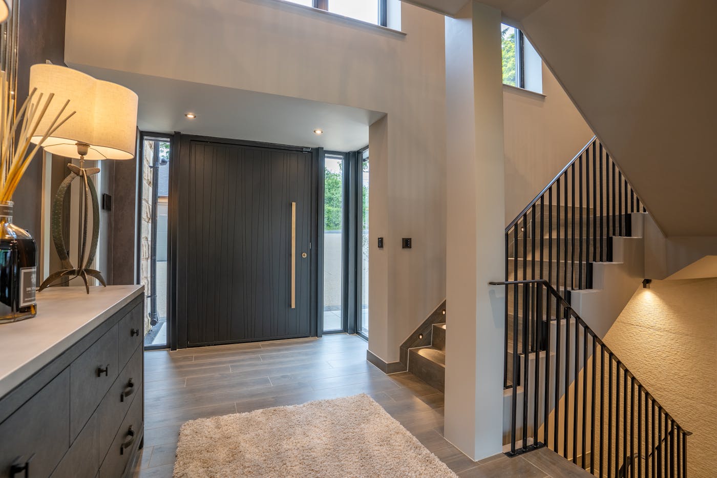 Sidelights and windows in a double height hallway allow light in