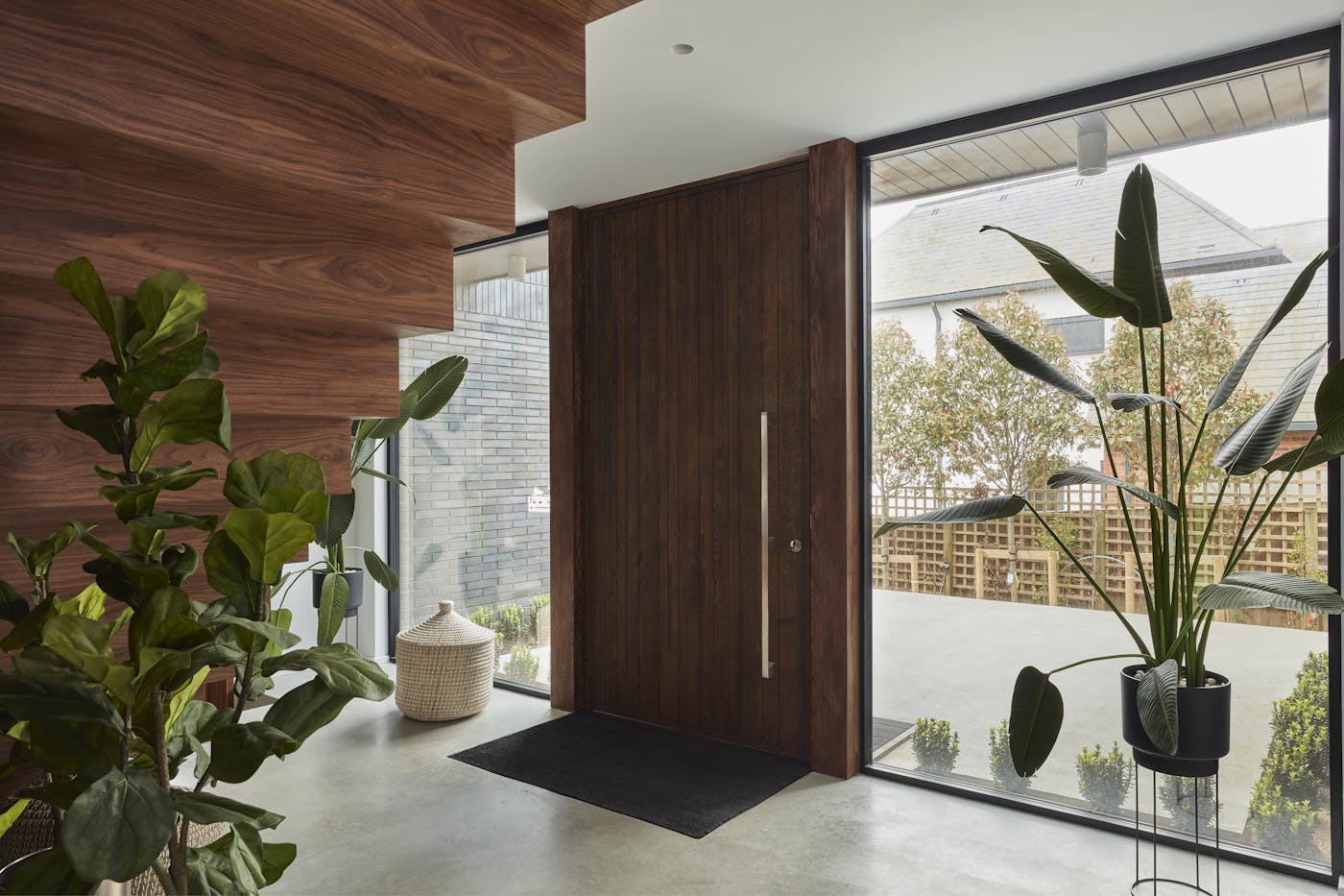 The greenery works beautifully against the dark wood door and stairs