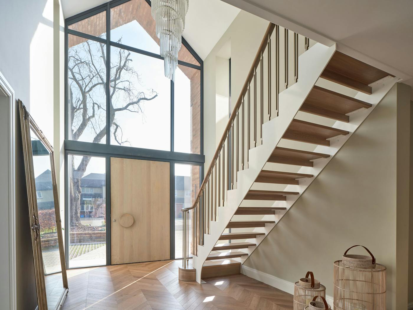 The simple staircase works beautifully with the flooring, oak door with statement Luna handle, and stunning glazing