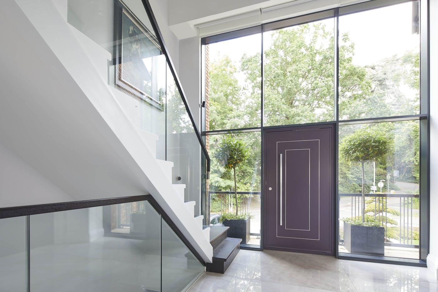 Gorgeous glazing, monochrome stairs and flooring allow the purple door to take centre stage