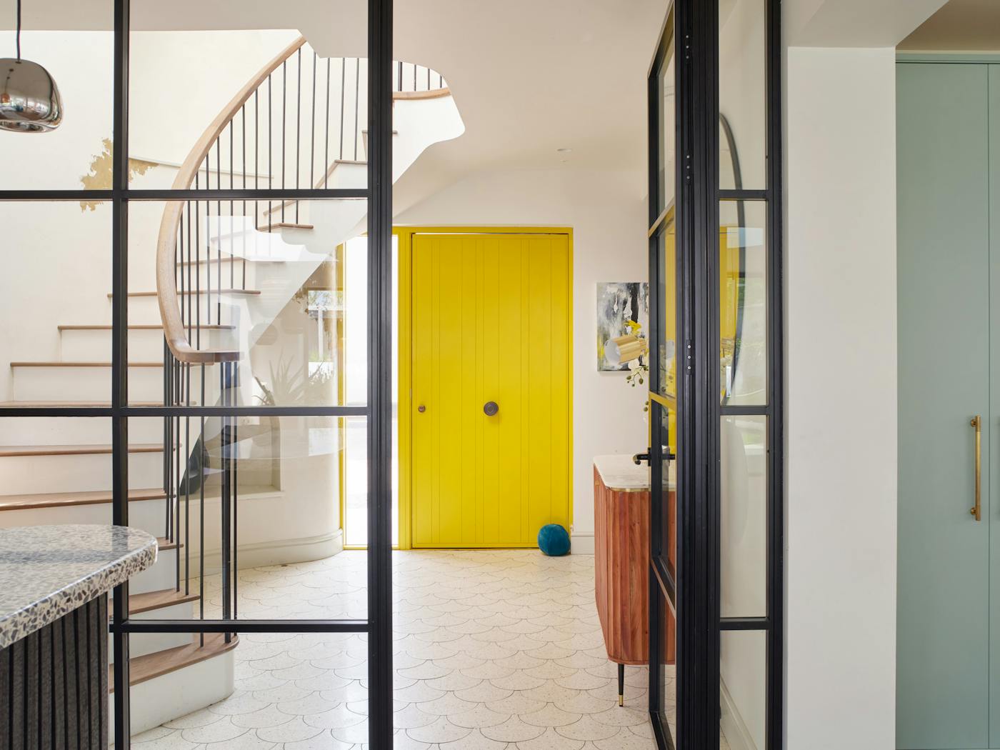 Crittall-style doors frame the bright yellow door