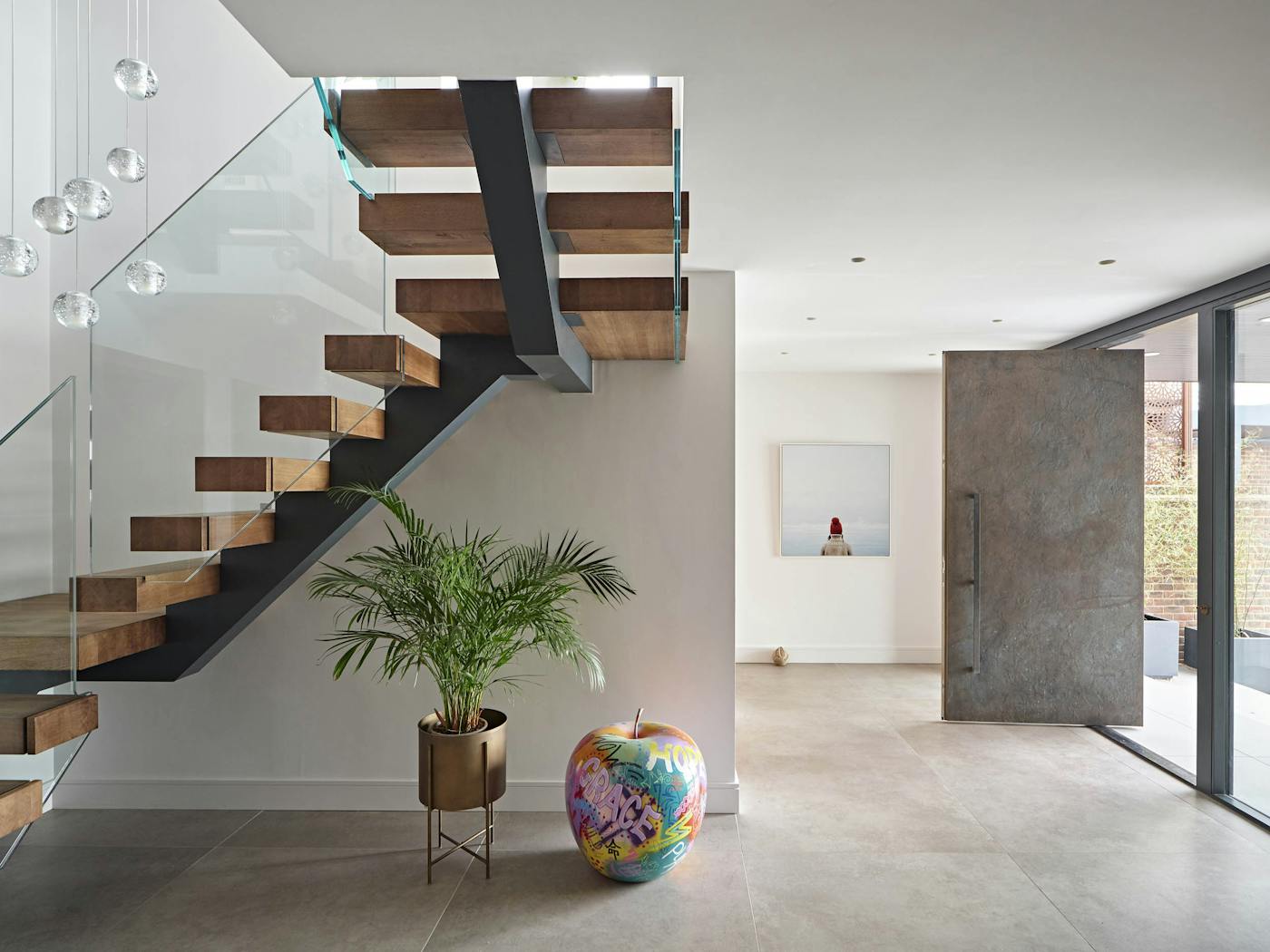 A generous hallway with unusual arty details and a bronze pivot door