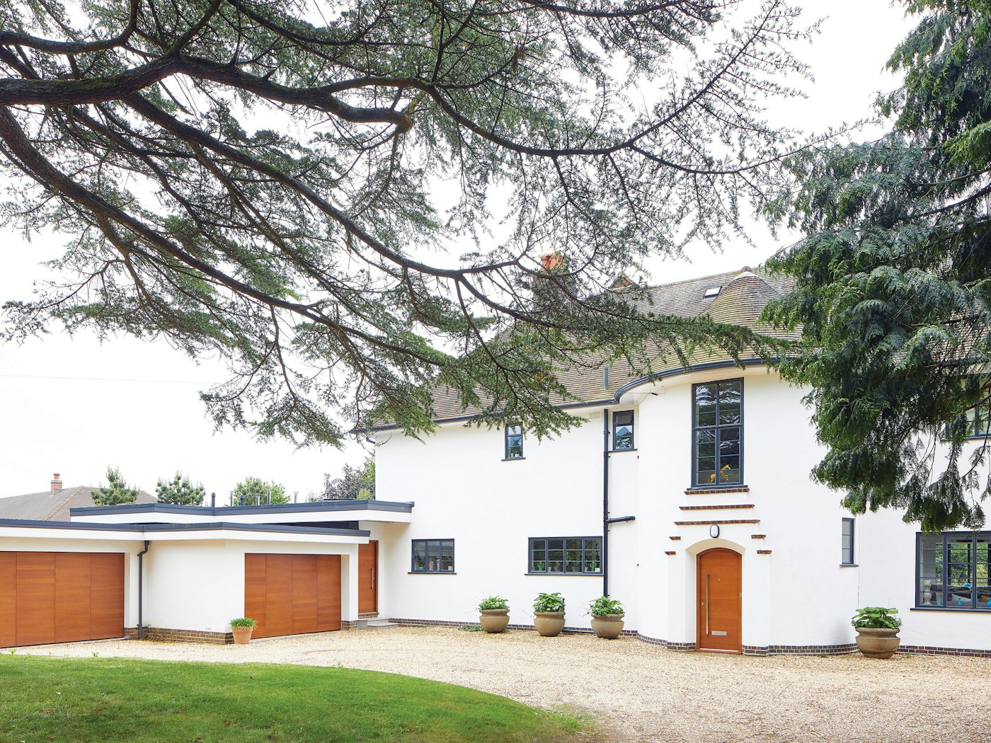 This house errs on the traditional side but is given a contemporary update with its white render and matching iroko front & garage doors in a simple design