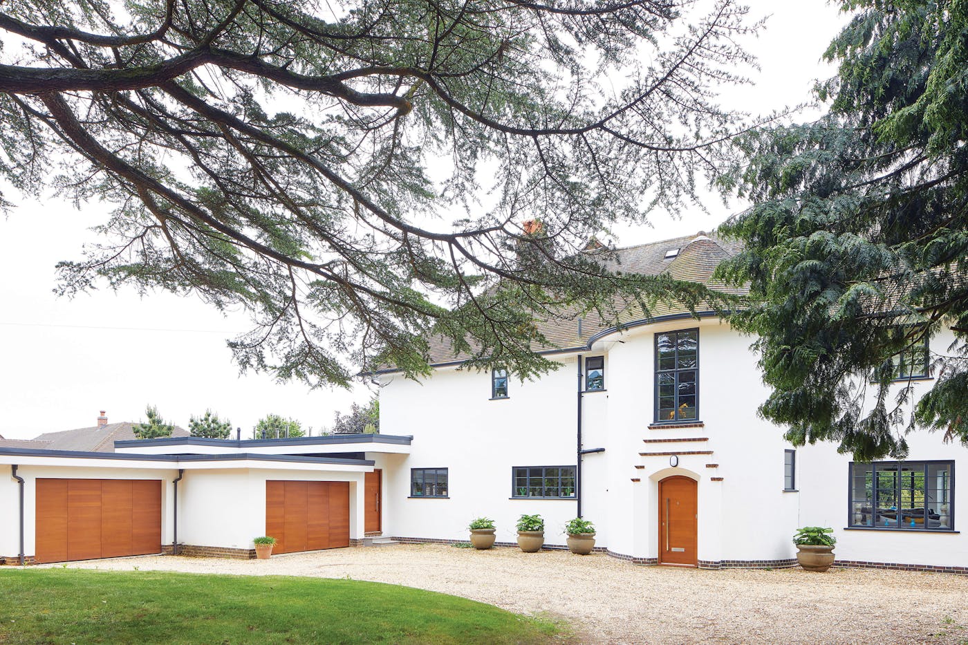 This house errs on the traditional side but is given a contemporary update with its white render and matching iroko front & garage doors in a simple design