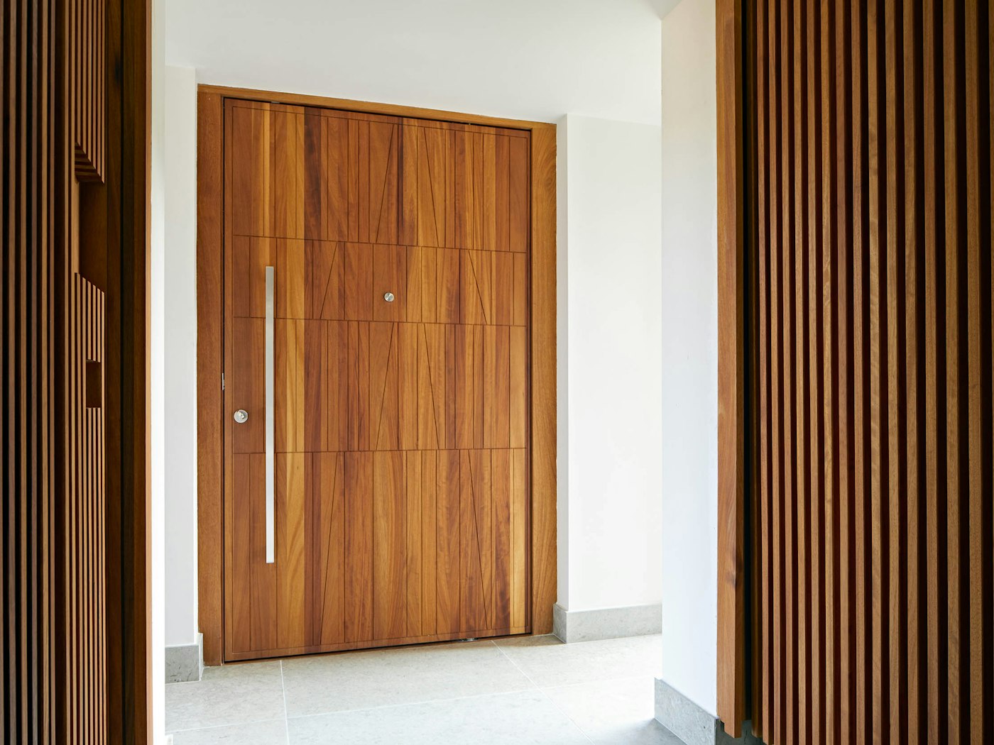 Stainless steel front door handle on iroko door