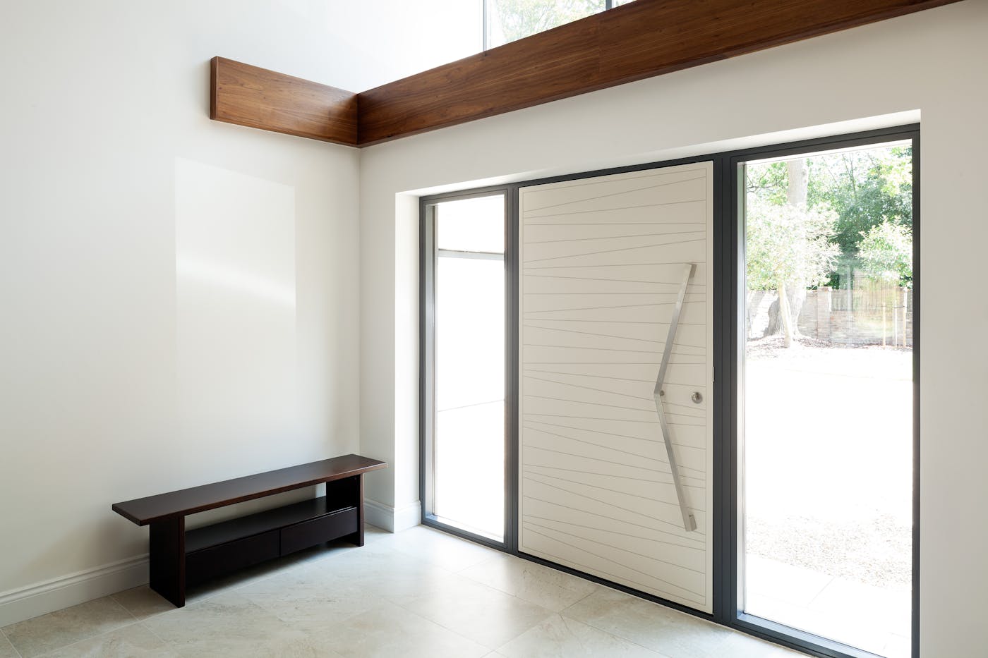 Double sidelights (side glass panels) frame this white RAL-painted door