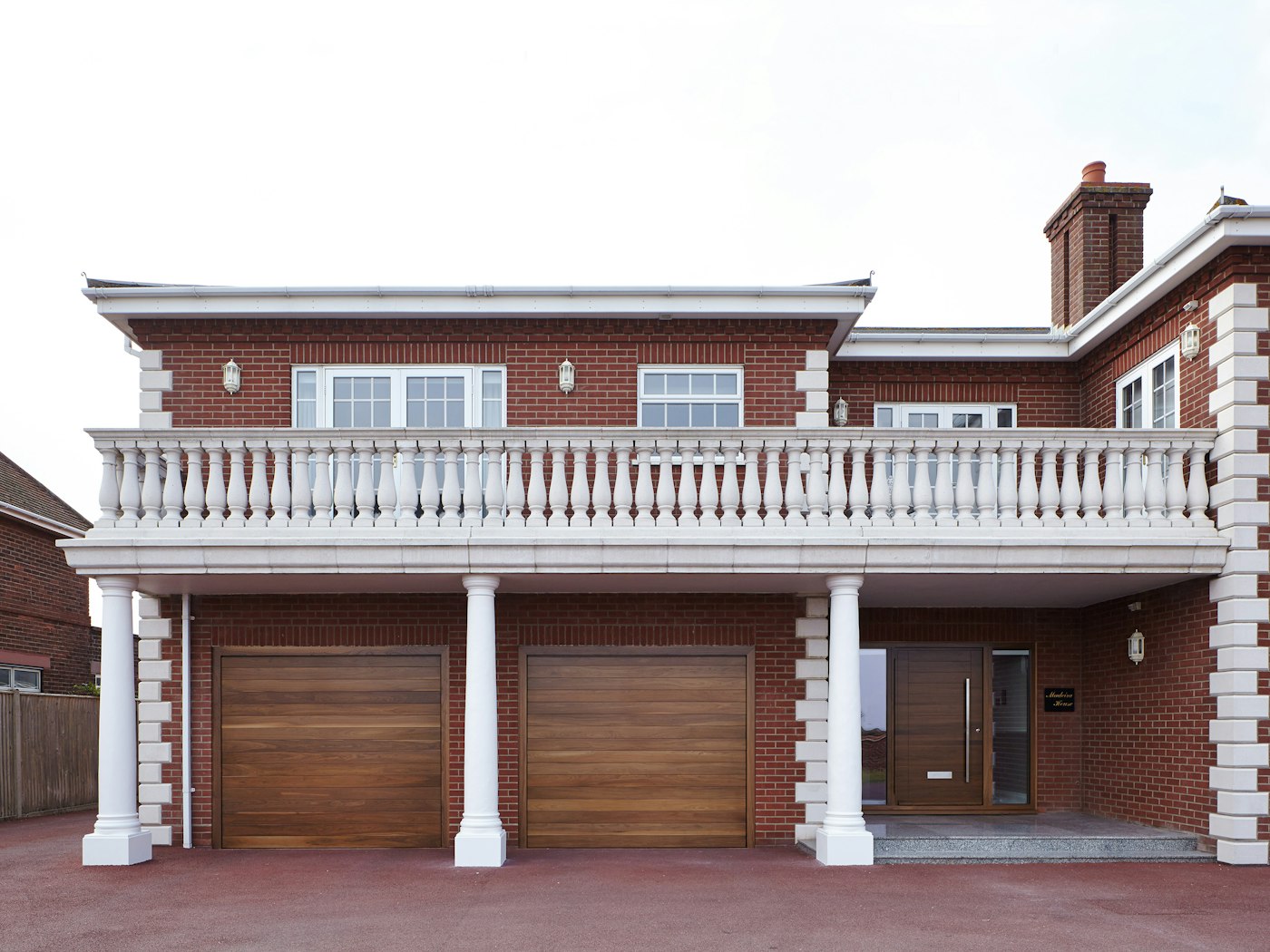 This mixed style new build perfectly blends the warmth of red brick with an Urban Front front door in walnut - along with matching garage doors