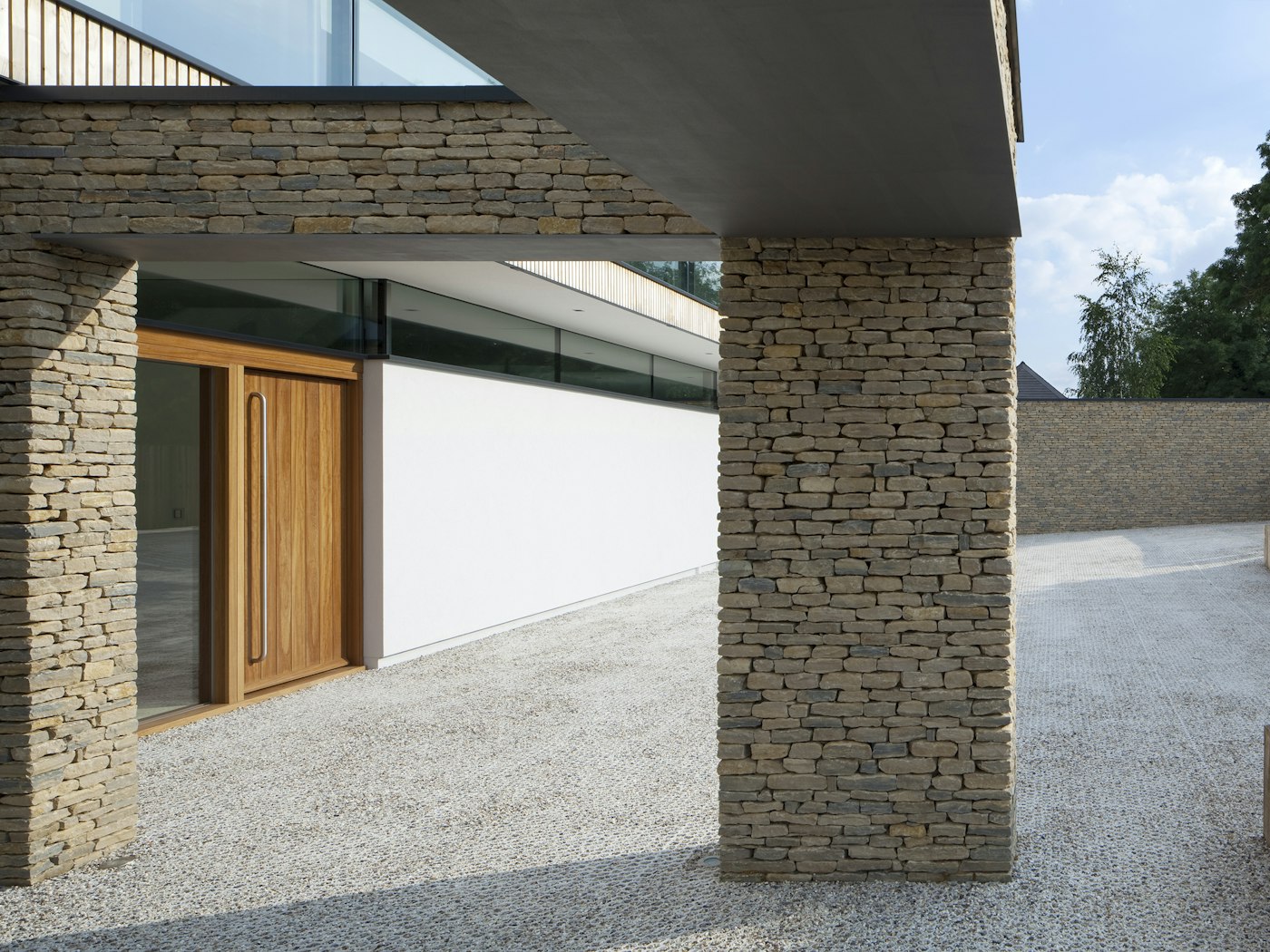 This contemporary house features mixed, light coloured stonework and the iroko front door stands out beautifully