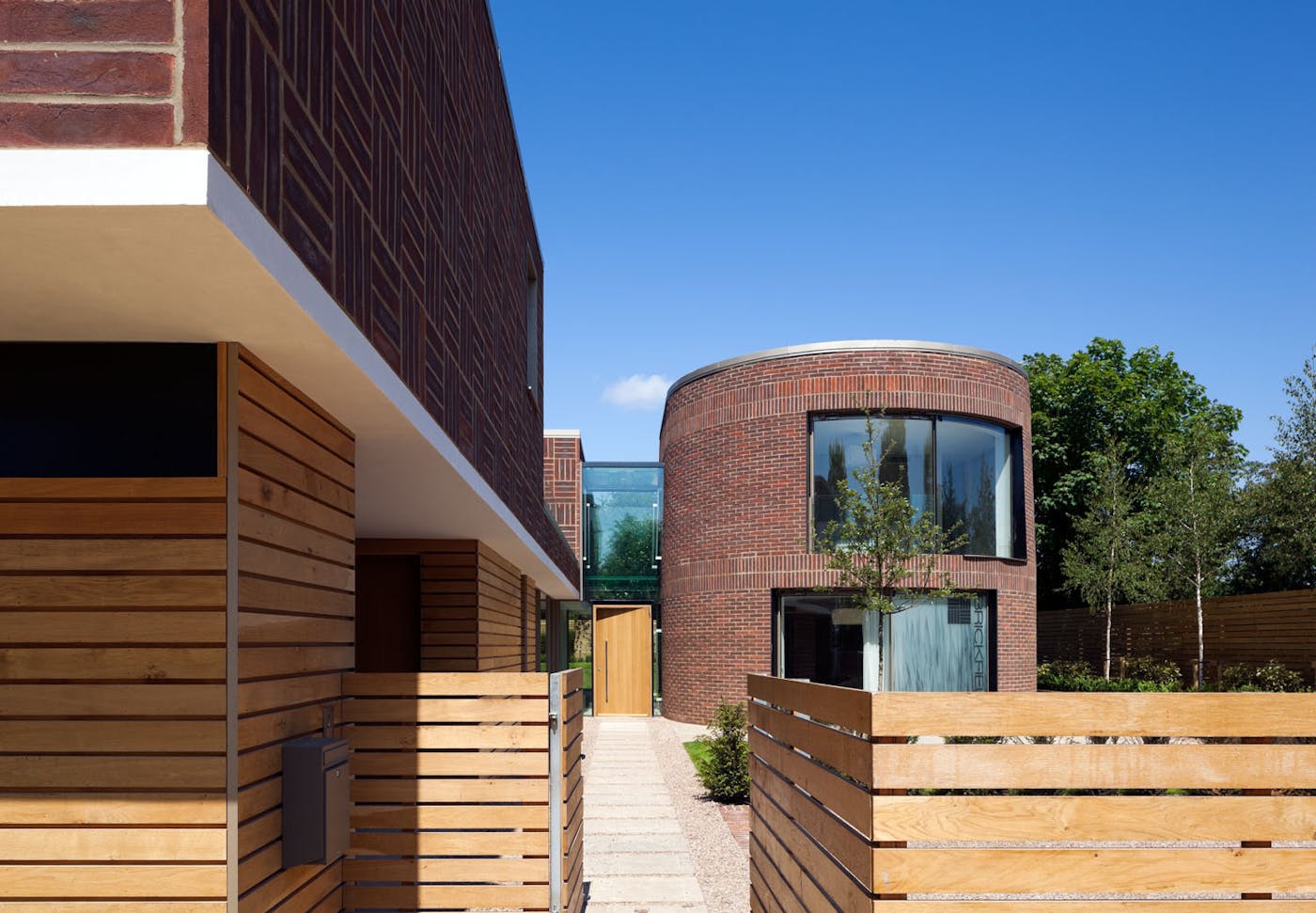 An unusual designed house with circular and square walls with a large door