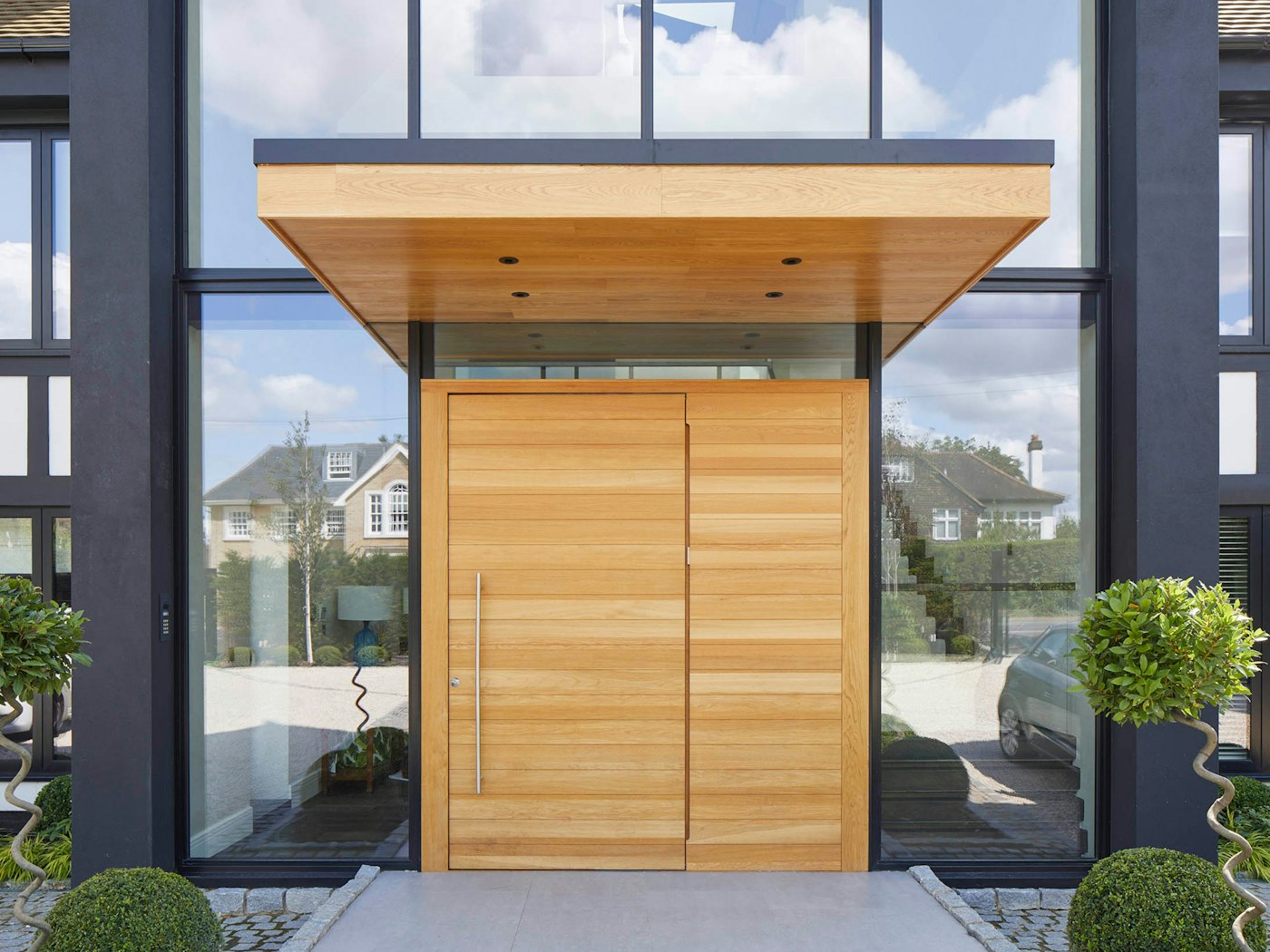 large overhangs will help protect a pivot door from exposure