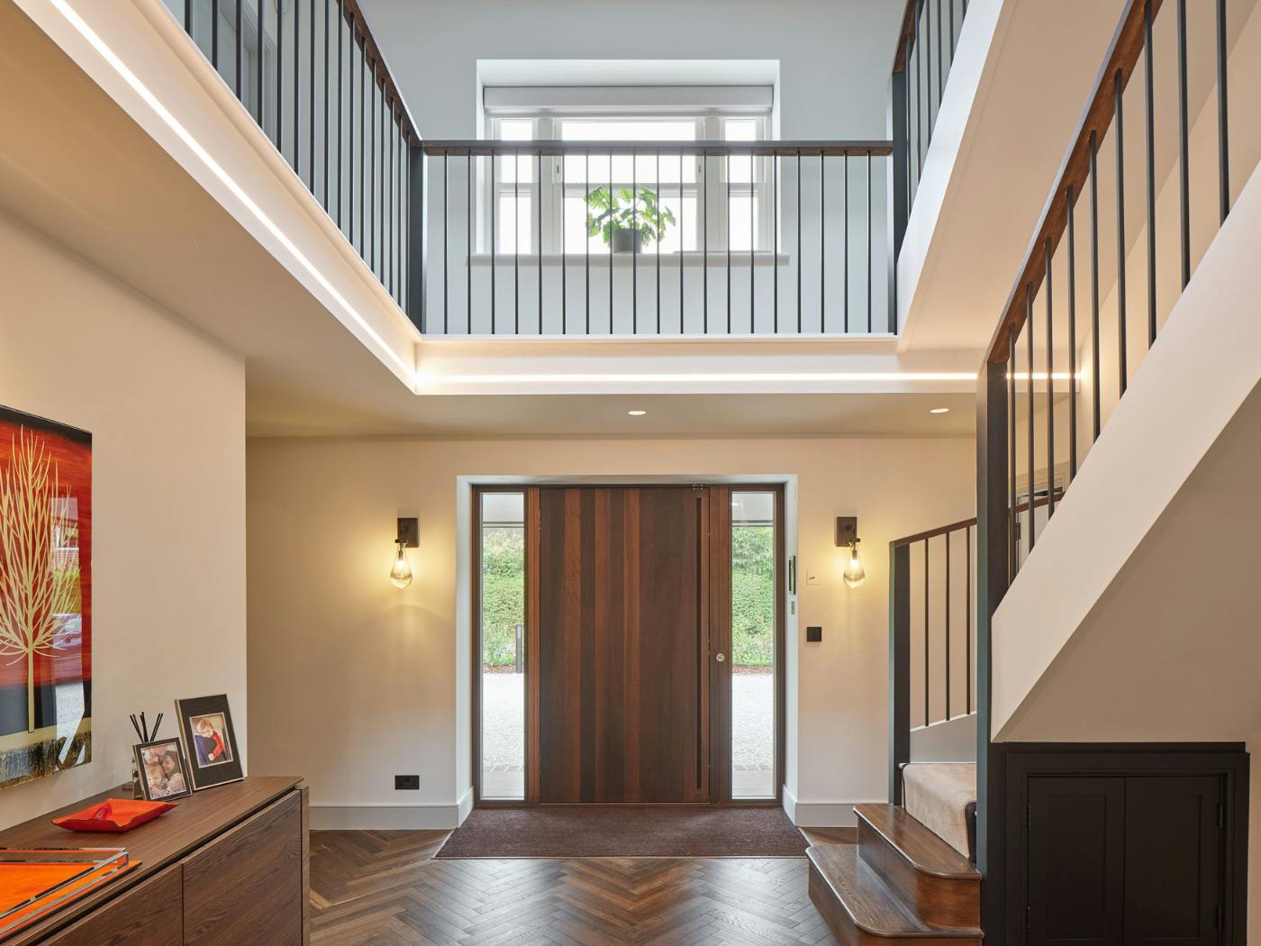 Dark wood and light walls make a stylish statement alongside an impressive staircase and bannisters 