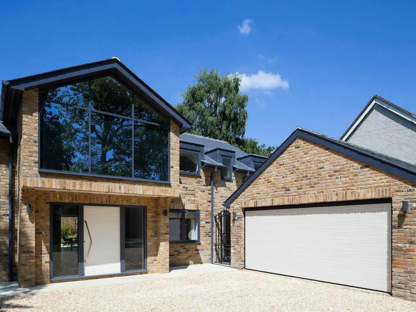 This contemporary house features white painted matching front & garage doors