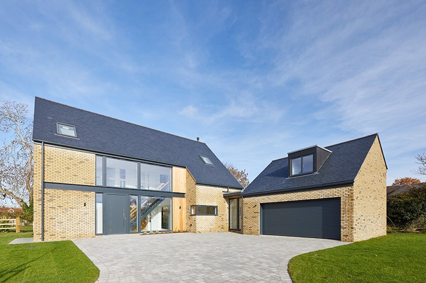 Set into architectural glass, the dark grey front door matches perfectly with the external building materials