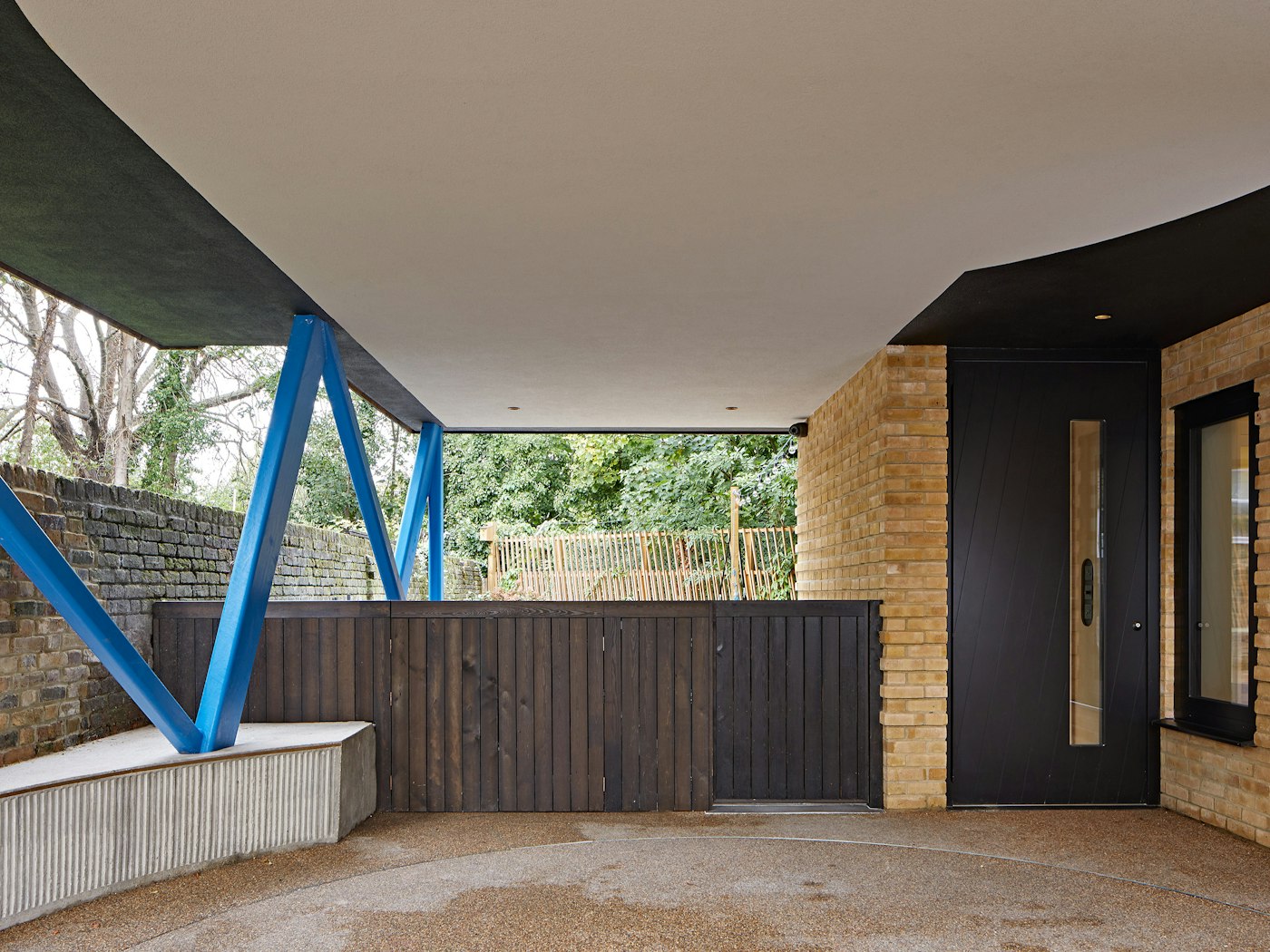 The covered porch space is accented by the attention grabbing blue legs holding the upper level