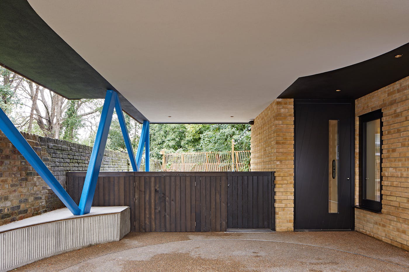 The covered porch space is accented by the attention grabbing blue legs holding the upper level