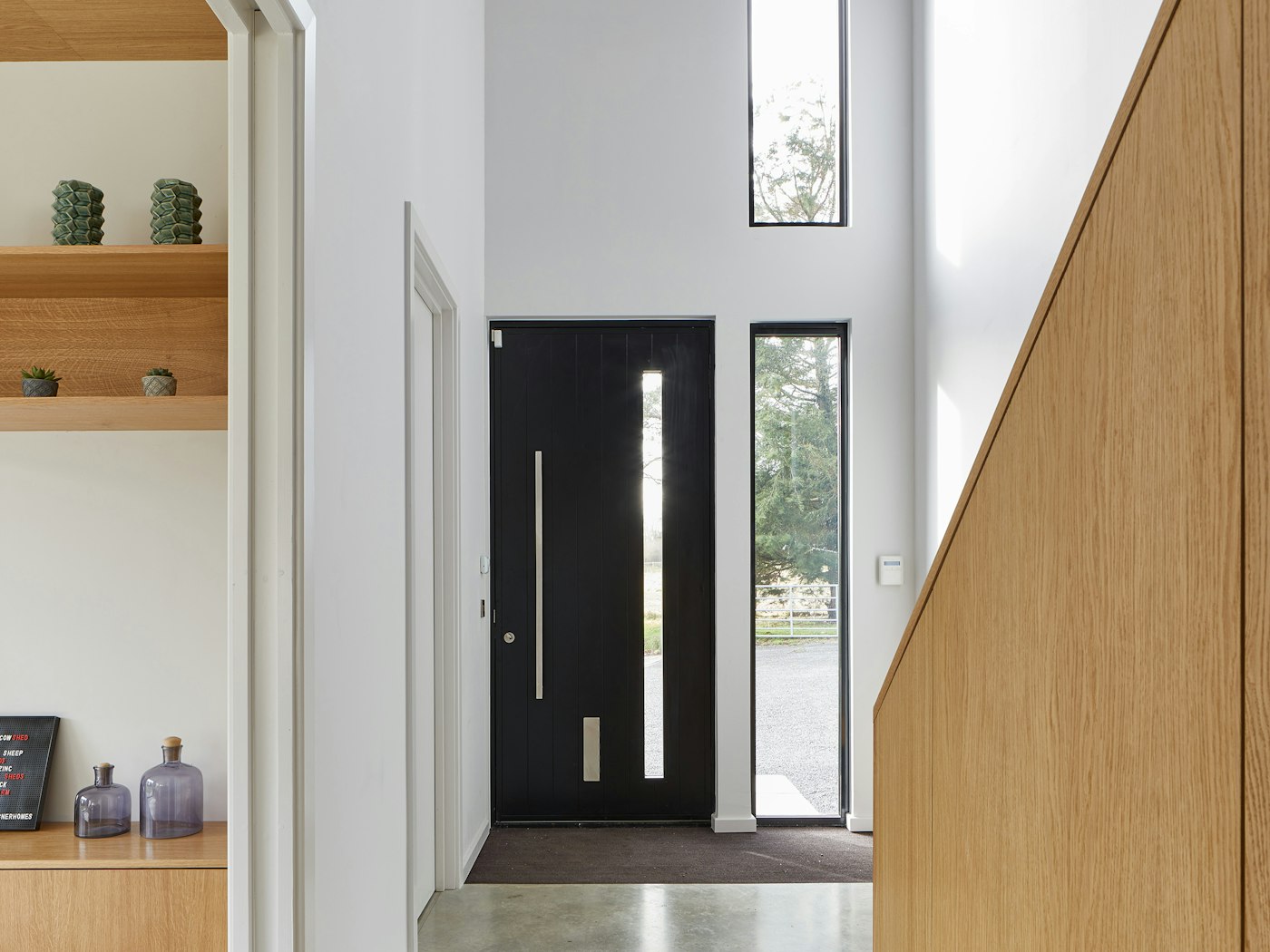 And inside the modern black door sits in a fresh hallway with ample light provided by the door's glass panel & additional windows