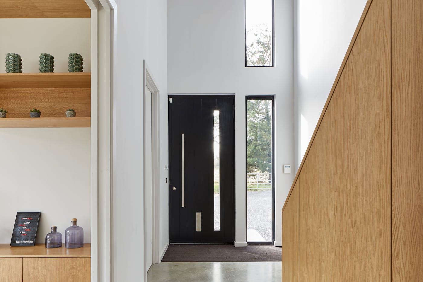 And inside the modern black door sits in a fresh hallway with ample light provided by the door's glass panel & additional windows