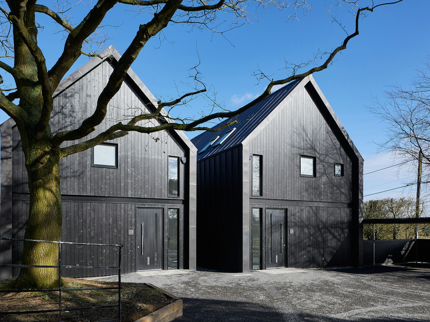 These contemporary houses were designed to mimic farm buildings, complete with black cladding & black exterior doors
