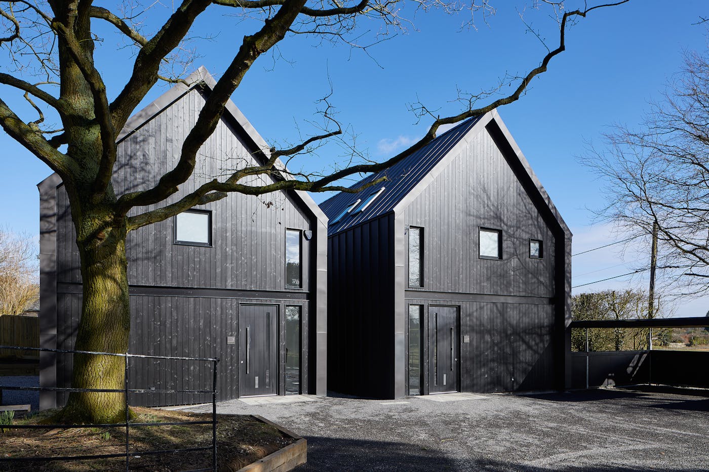 These contemporary houses were designed to mimic farm buildings, complete with black cladding & black exterior doors