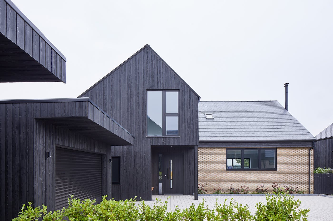 Urban Front's black painted Terano doorsets work well with the charred cladding in this development