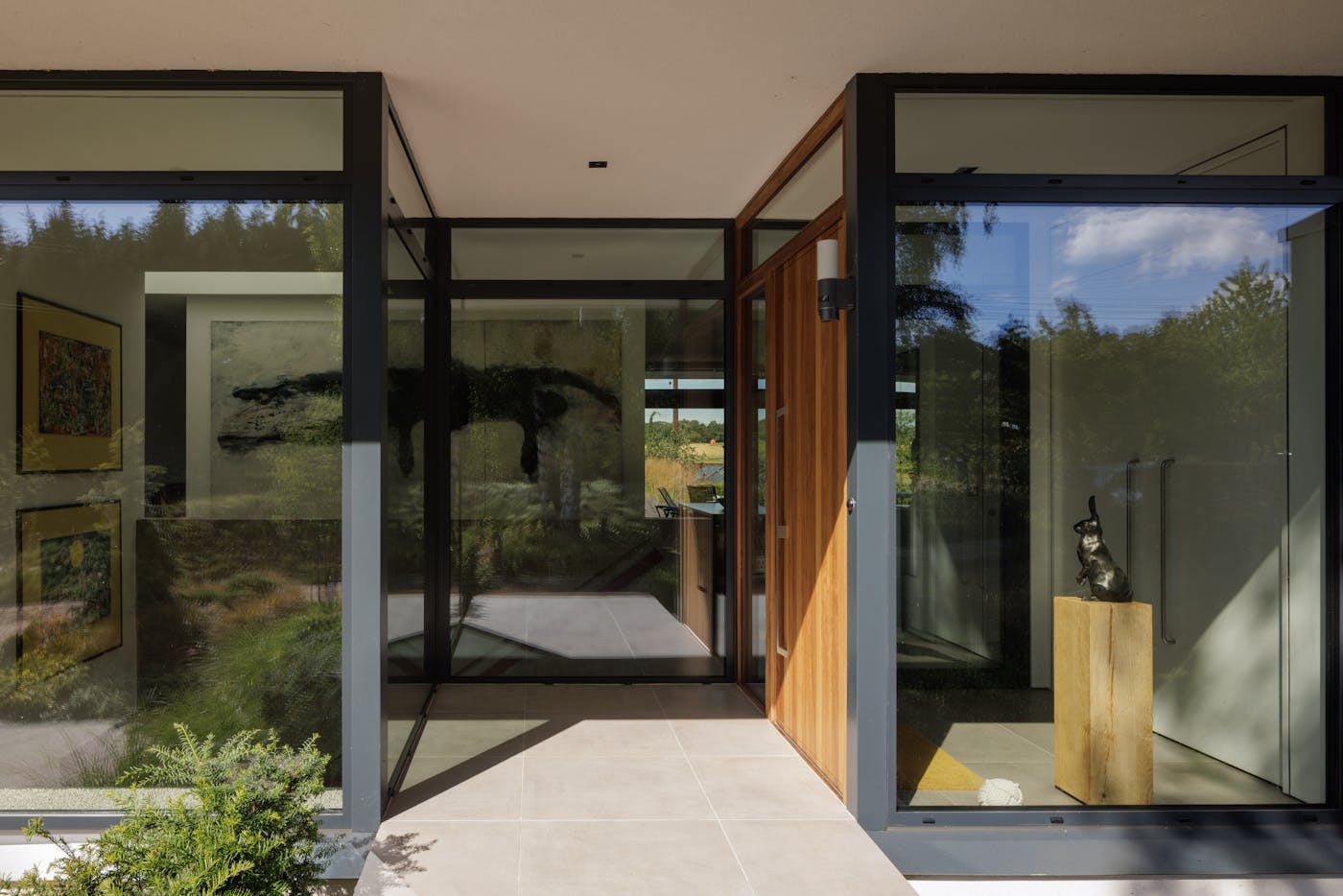 The door sits in the recessed porch of this heavily glazed eco house