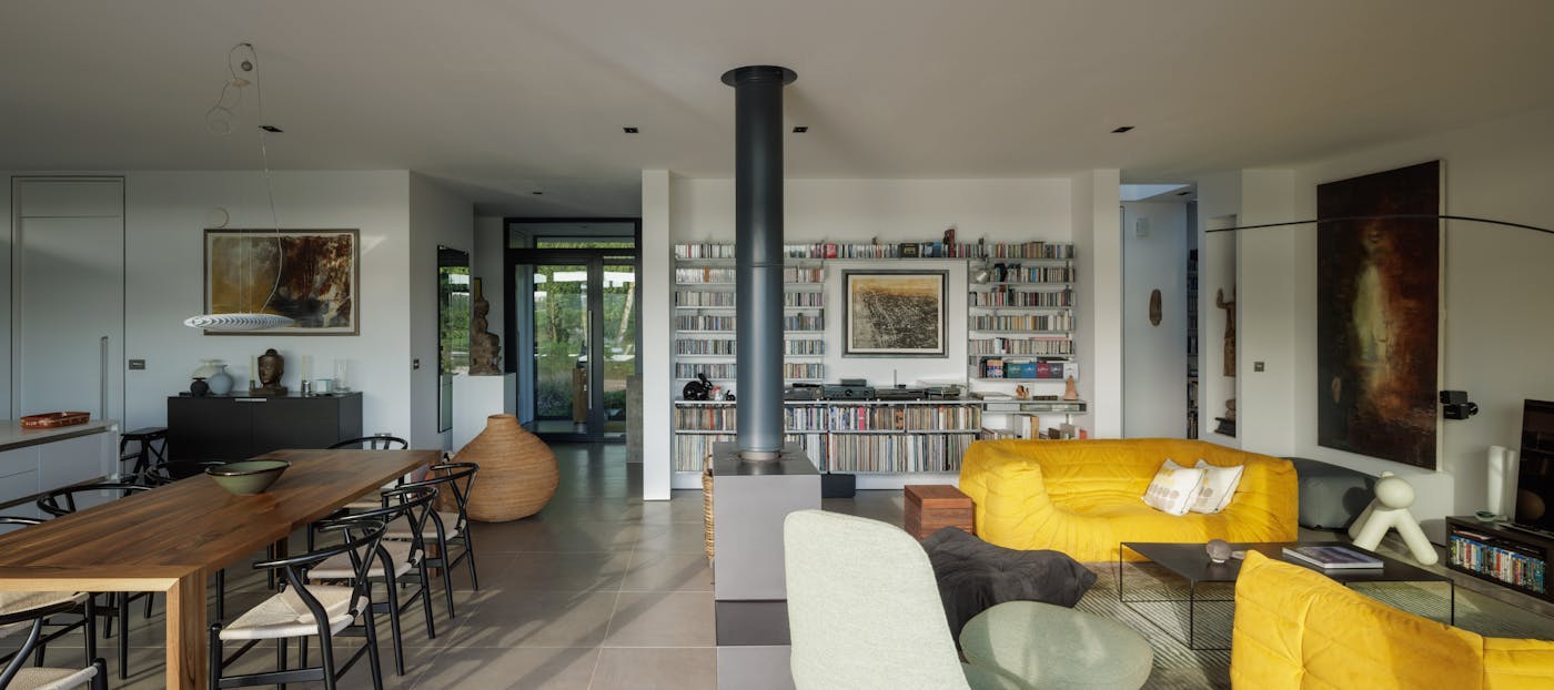 And the open-plan space continues through the lounge area, that is accented by bold yellow sofas