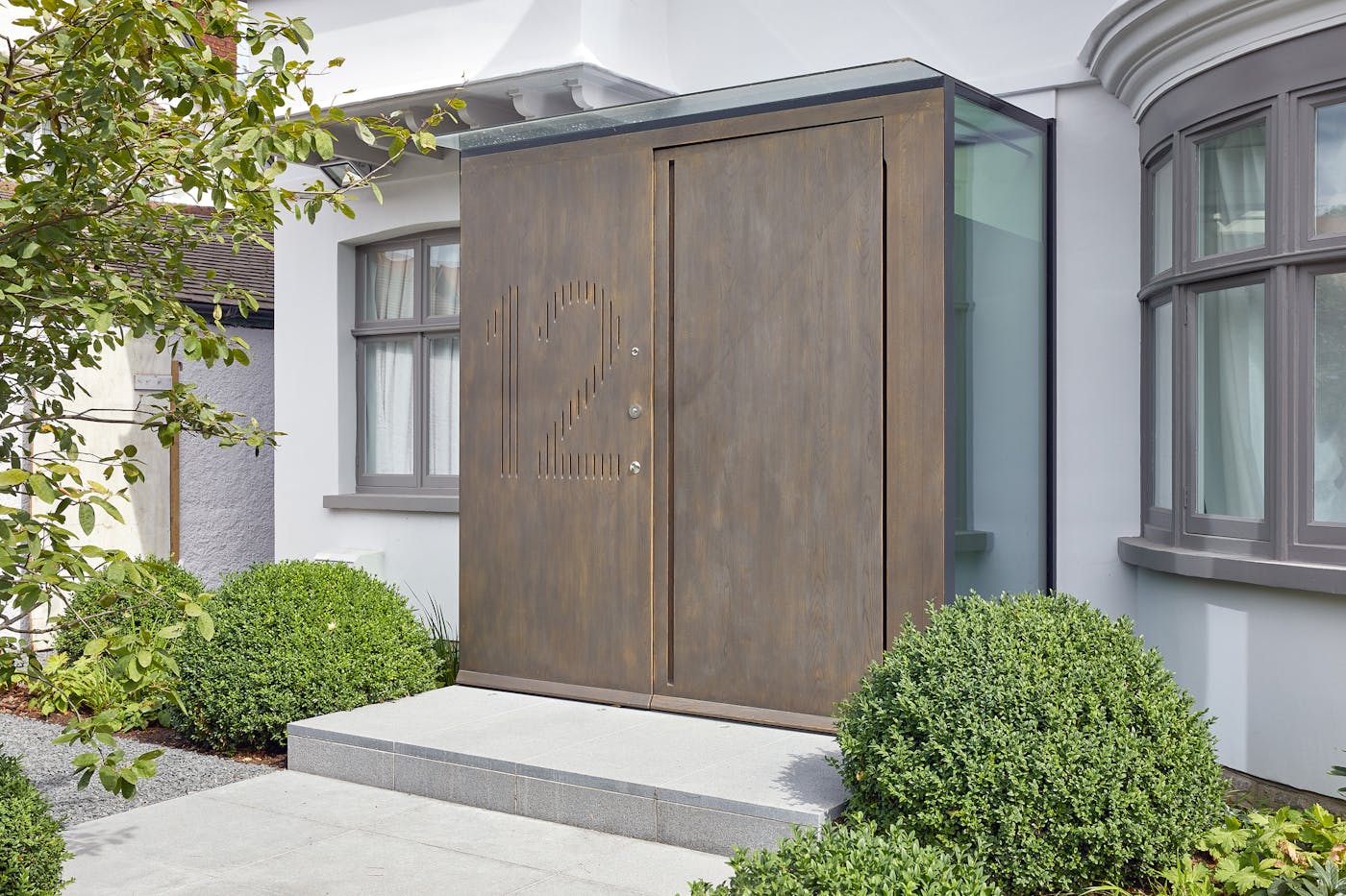 Raw E80 pivot door set with matching boarded panel with number engraving in European stained Onyx metallic finish 