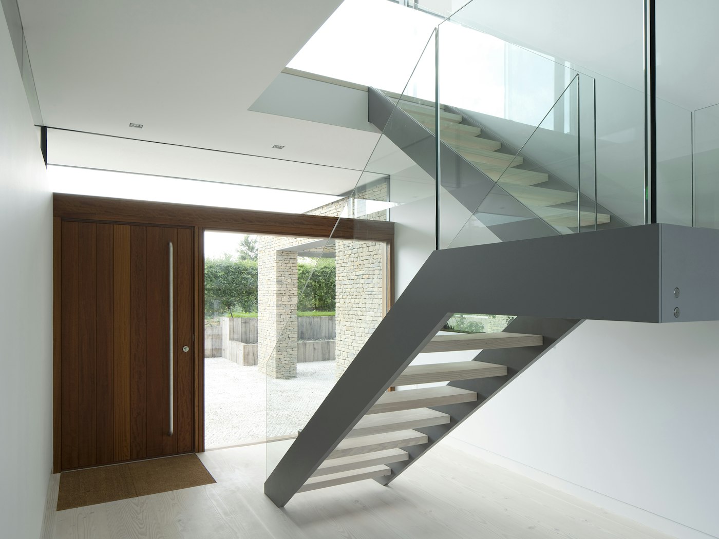 The minimalist interior is made even more impressive with the contrasting front door and staircase