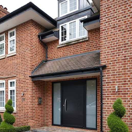 Traditional brick house with Numero black front door 