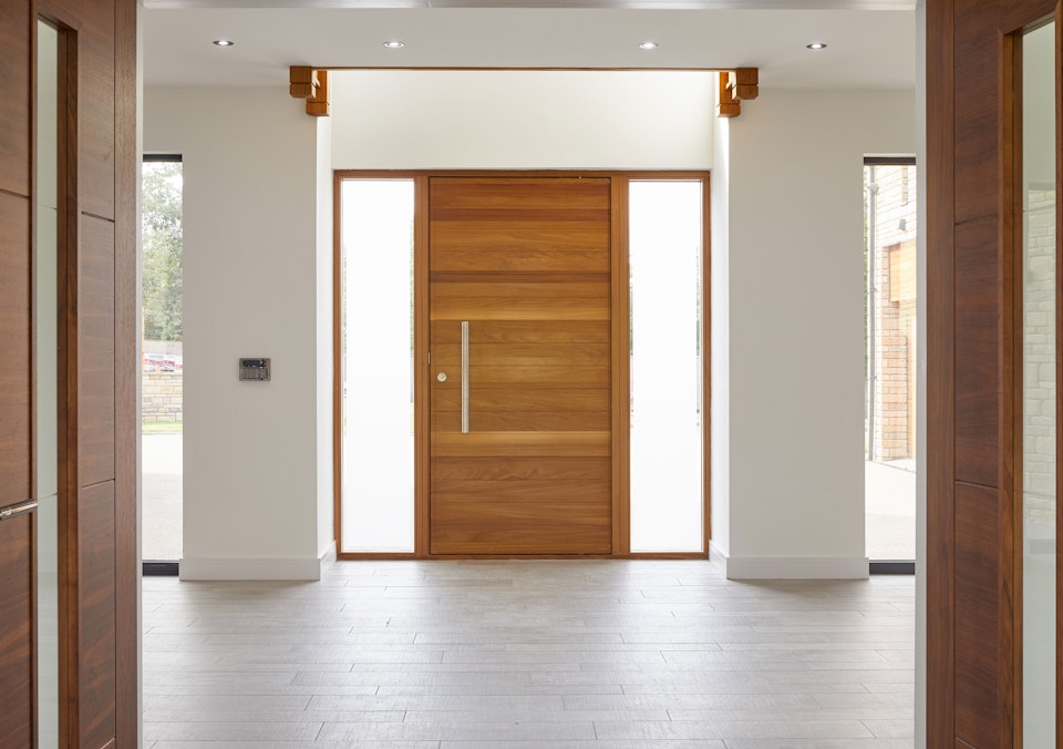 The light modern interior highlights the beauty of the front door 
