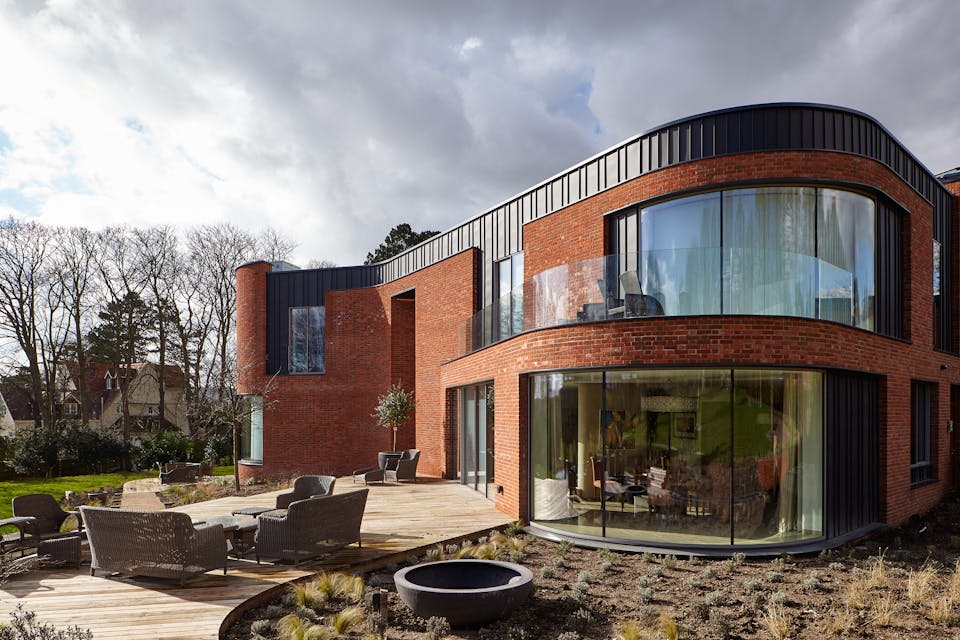 The curved passive house design features 5 Urban Front external doors 