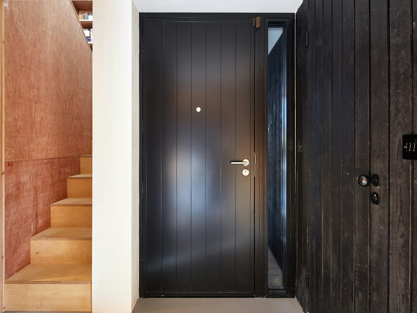 Urban Front's Porto passive front door next to the black cladded wall