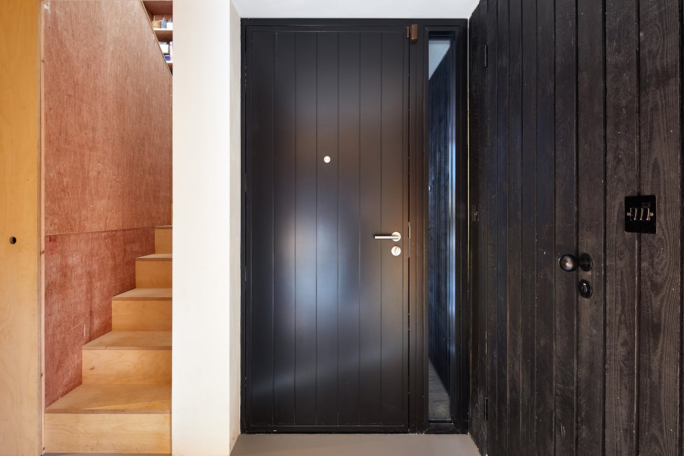 Urban Front's Porto passive front door next to the black cladded wall