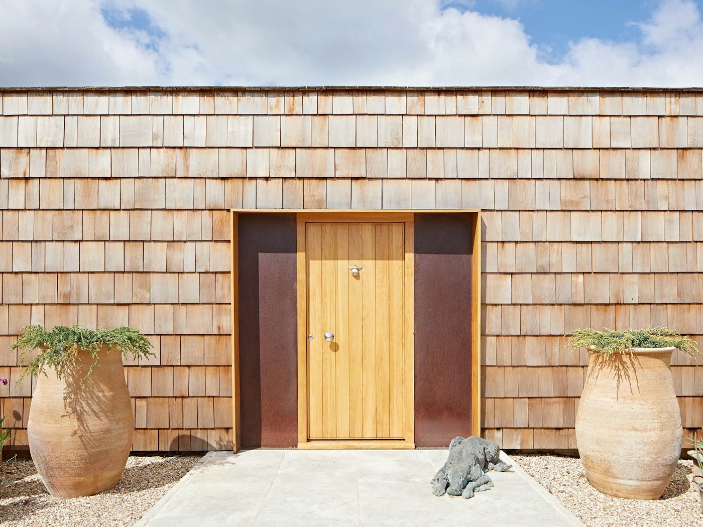 Our Passive oak front door is artfully framed by weathered steel side panels and the unique shingles