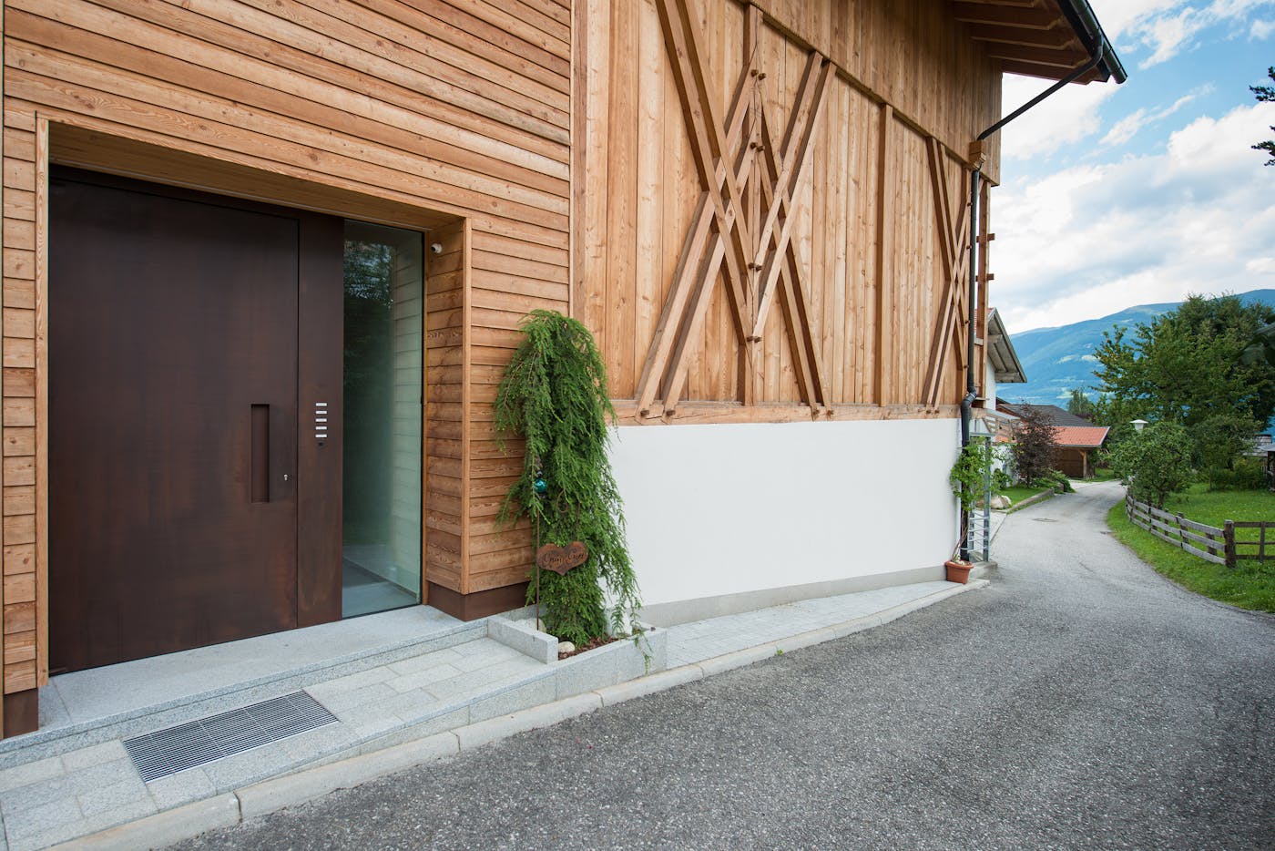 "Raw" steel front door in rust (corten steel), with concealed handle & glass sidelight