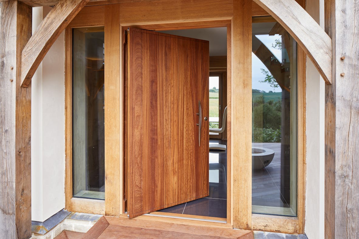 Rondo V door design in iroko + bronze handle and pivot opening